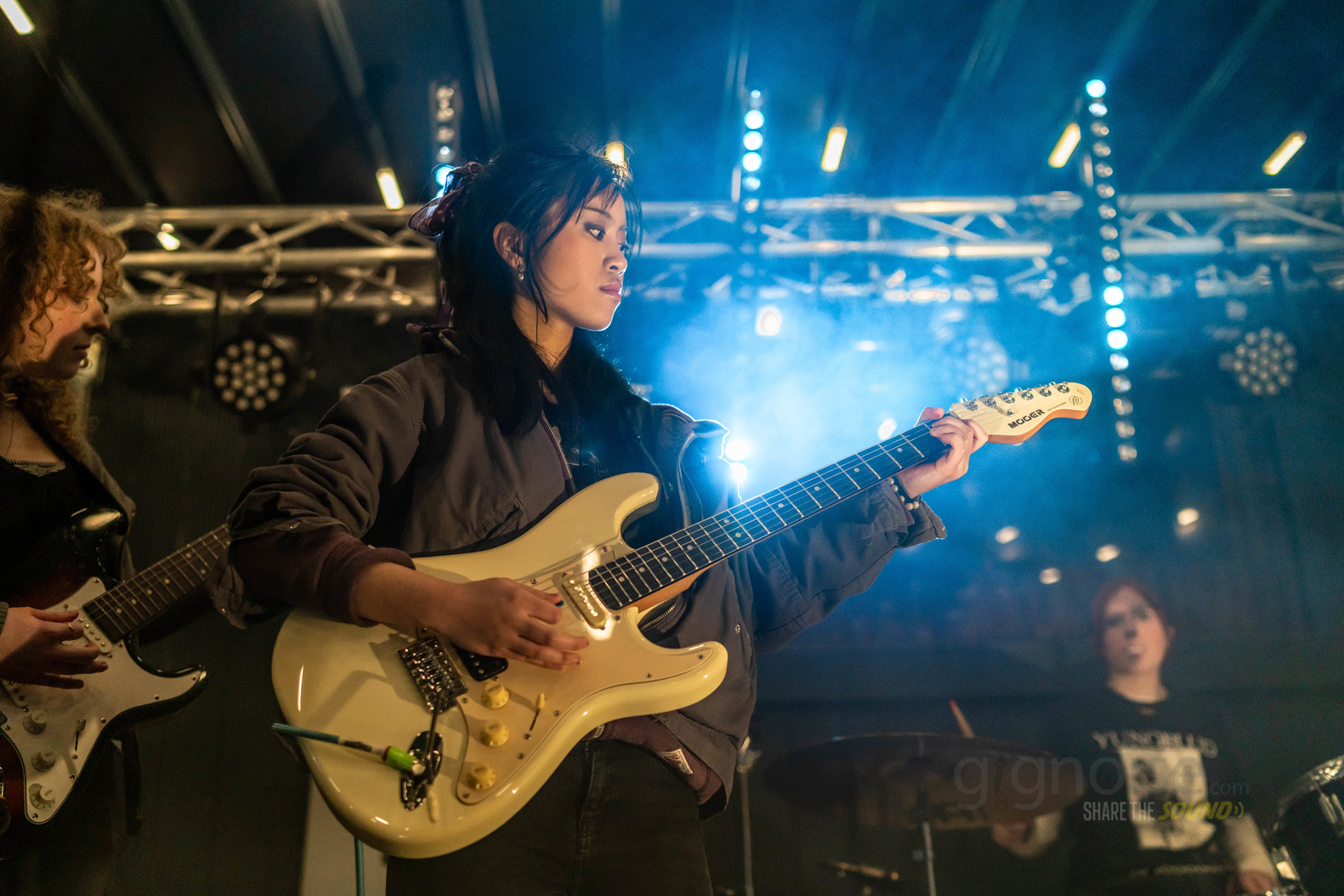 Guitarist performing under blue stage lighting